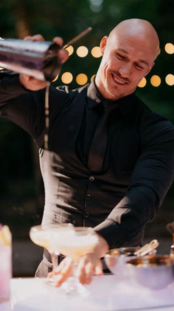 Experienced bar staff bartender preparing live cocktail service during a San Francisco tech event, supporting evening networking operations with high-volume beverage execution, guest interaction, and fast-paced hospitality coordination.