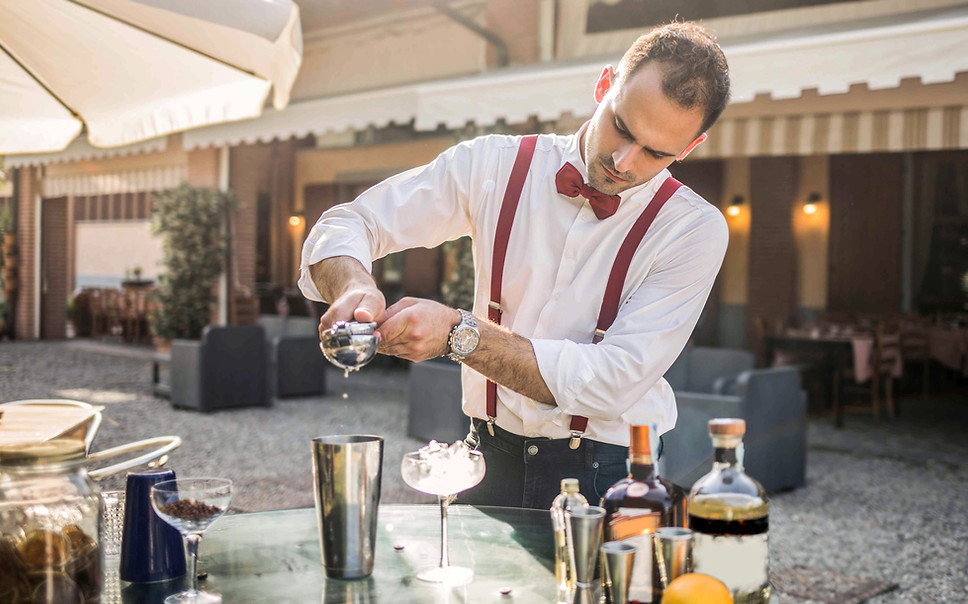 Professional bar mixologist in Los Angeles preparing a craft cocktail at an outdoor event bar, representing experienced event bar staff for private parties, weddings, corporate events, and brand activations. The image highlights hands-on mixology, precise measurements, premium spirits, and refined cocktail presentation. Ideal for clients hiring event bar staff in Los Angeles who need skilled bar mixologists capable of creating signature cocktails, managing high-end bar setups, and delivering consistent, guest-focused beverage service in fast-paced event environments.