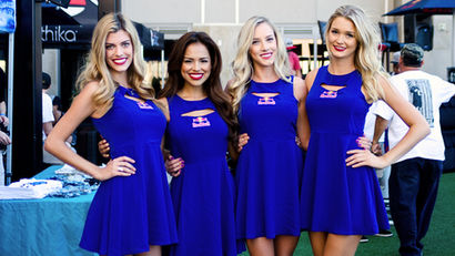 Group of professional promo models in San Francisco wearing coordinated branded dresses at an outdoor activation, standing together and engaging guests in a lively event environment. This image highlights promo model services in San Francisco for brand activations, trade shows, and product launches, showcasing polished appearance, confident presentation, and strong customer interaction designed to attract attention and drive engagement.