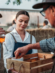 Buffet attendant assisting guests at an outdoor Los Angeles fair-style event, managing a self-serve food station and helping maintain organized meal distribution during a community gathering, festival reception, or open-air catered celebration.