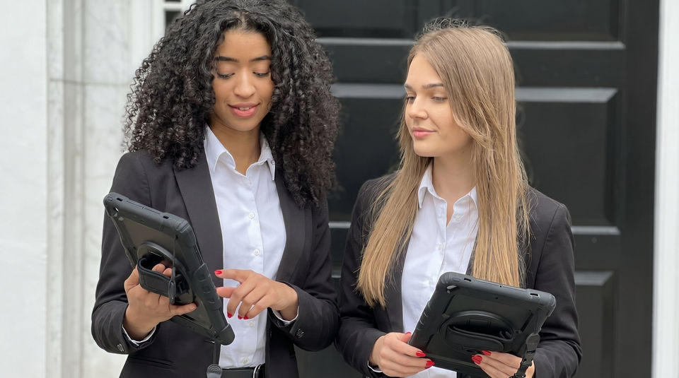 Tech conference registration staff in San Francisco using digital check-in systems and tablets for attendee verification and fast guest registration support.
