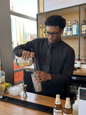 Experienced bartender preparing handcrafted cocktails during a San Francisco executive happy hour event, supporting beverage service operations and guest hospitality at a private rooftop venue overlooking the Embarcadero.