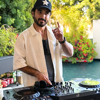 A DJ performs live behind a professional mixing console at an outdoor private event in Los Angeles, creating an energetic atmosphere for guests. Experienced Los Angeles event DJ providing music entertainment for corporate events, luxury private parties, weddings, rooftop celebrations, brand activations, and VIP receptions.