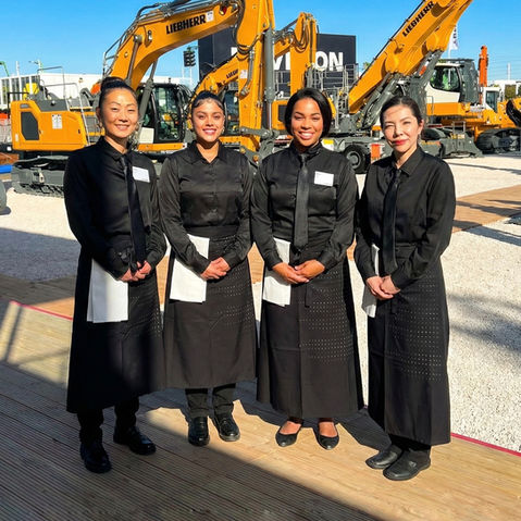 Hospitality servers supporting a Las Vegas trade show event at a major convention venue. Professional food and beverage staff providing exhibitor hospitality, VIP guest service, networking reception support, and catering assistance during a large-scale industry expo.
