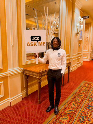 Crowd navigation staff member assisting attendees at a Las Vegas conference venue, holding an information sign and helping guests locate sessions, meeting rooms, and event services. Professional wayfinding staff supporting attendee guidance and smooth traffic flow during a large convention.