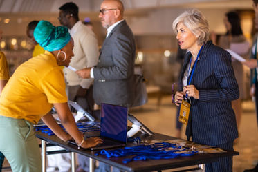 Las Vegas conference guest registration staff assisting attendees at a professional registration desk during a corporate conference. Registration team members organize name badges, manage attendee materials, and support credential verification for arriving guests. Conference guest registration staff in Las Vegas providing organized check-in services, handling VIP arrivals, coordinating badge distribution, and maintaining smooth entry flow for business conferences, leadership summits, and large-scale professional events.