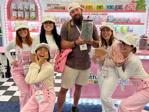 Trade show brand ambassadors and promotional staff in Las Vegas interacting with attendees during Sweet & Snacks Expo at Las Vegas Convention Center featuring experiential booth marketing, product sampling activation, and corporate trade show staffing support in Las Vegas
