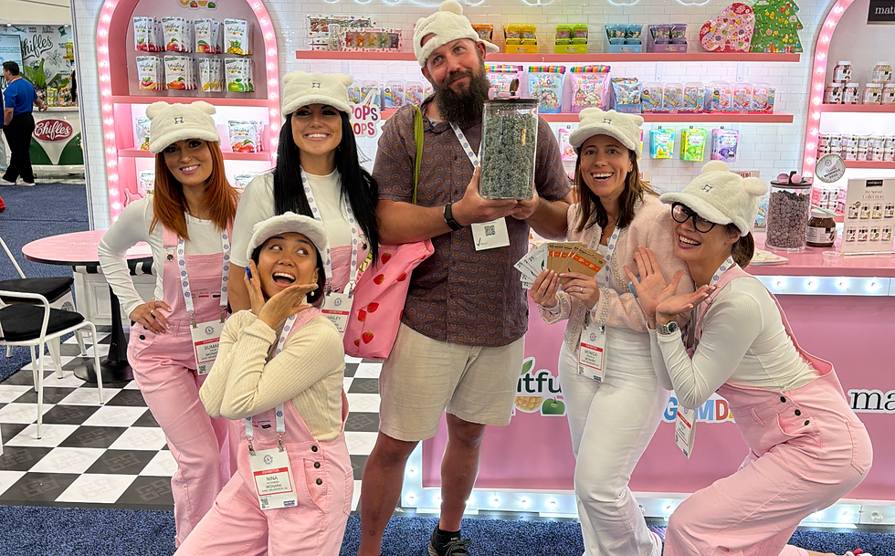 Trade show brand ambassadors and promotional staff in Las Vegas interacting with attendees during Sweet & Snacks Expo at Las Vegas Convention Center featuring experiential booth marketing, product sampling activation, and corporate trade show staffing support in Las Vegas