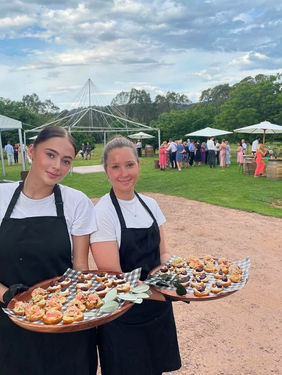 Food and drink servers in San Francisco carrying passed appetizers during an outdoor Bay Area reception, supporting catering operations, guest hospitality, and banquet service at a large private networking event.