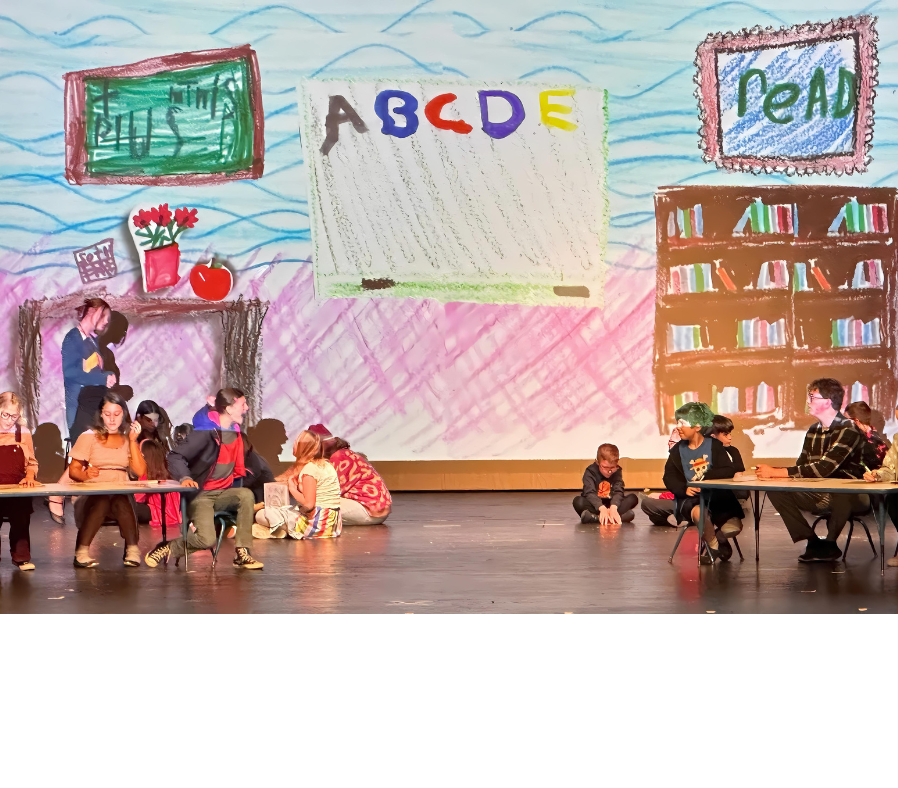 Junie B. Jones and Jim sitting at their own tables, with Junie B. yelling at Jim, while the other kids quietly work at their desks.
