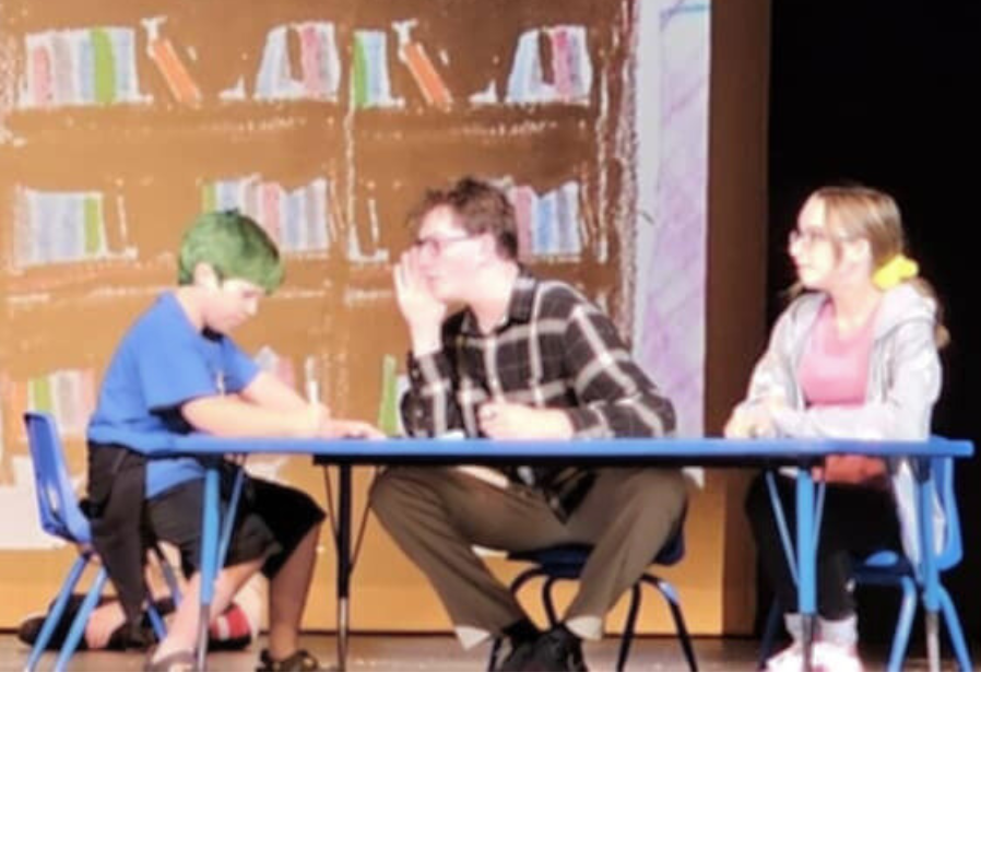 Jim whispering to Ricardo while sitting at their table with Grace.