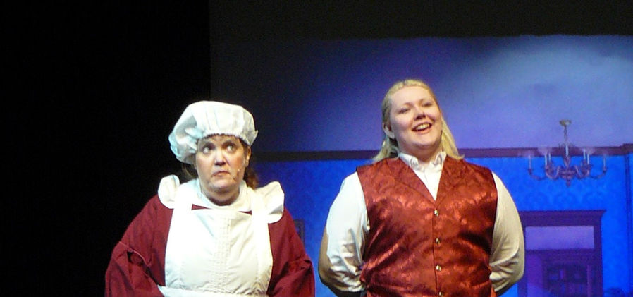 Mrs. Brill and Robertson Ay, (played by Kristi Hibschman and Jessi Ball)the Banks family's servants, stand side by side, dressed in traditional servant attire.