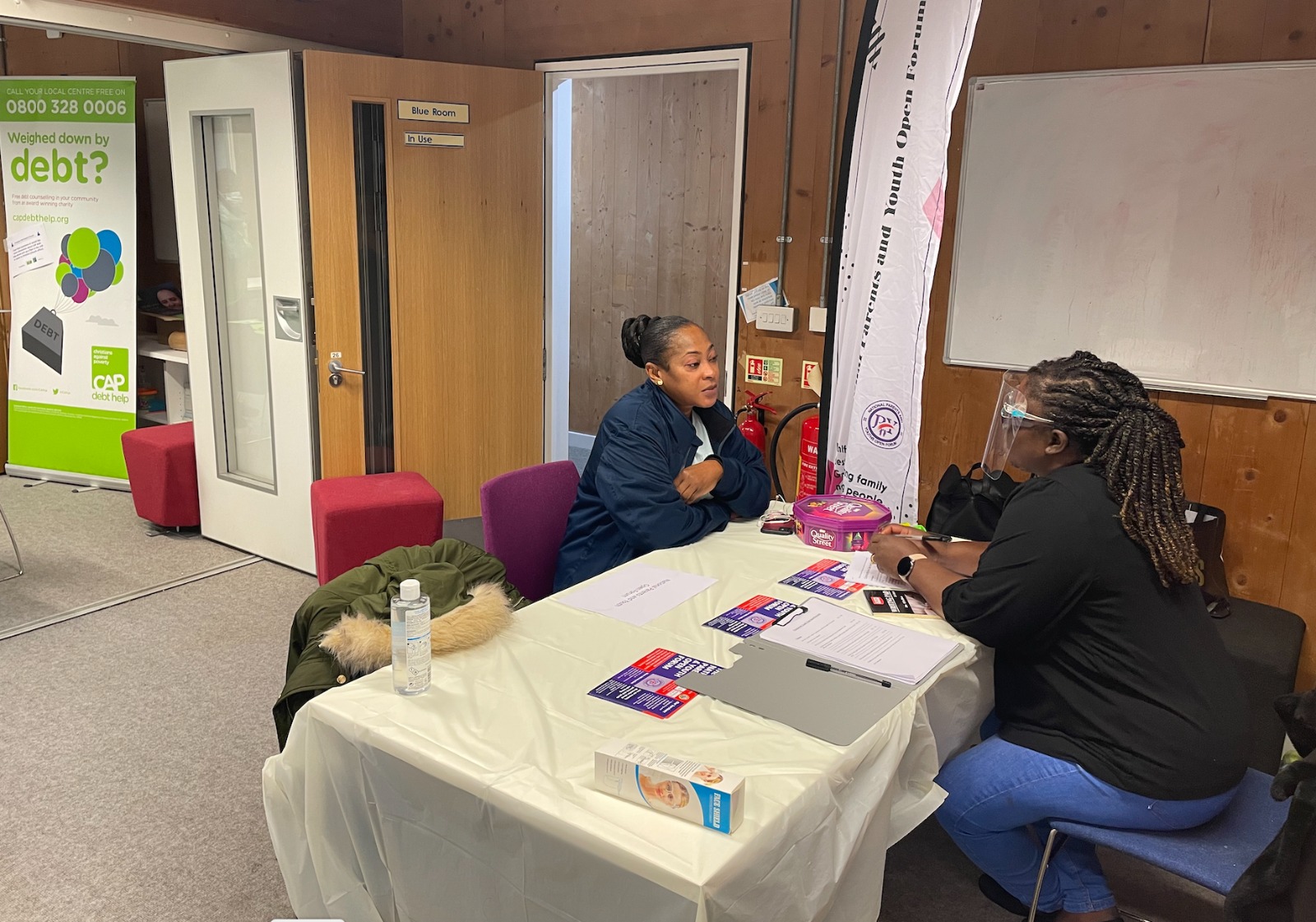 A resident speaking with a member of the NPAYOF health support team