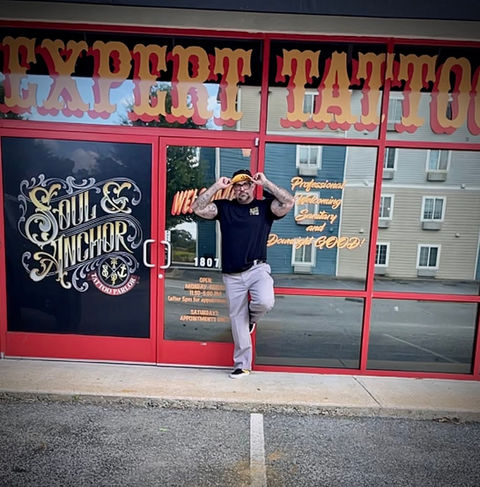 Soul and Anchor Tattoo Parlor owner at store front 