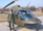 Mann im Fluganzug vor einem Militärhubschrauber