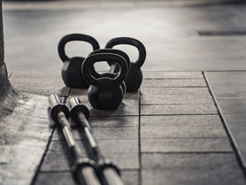 Kettlebells and barbells on a gym floor