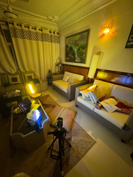 a living room with a laptop and a camera on a tripod