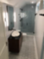 Bathroom vanity with herringbone tile and mirror