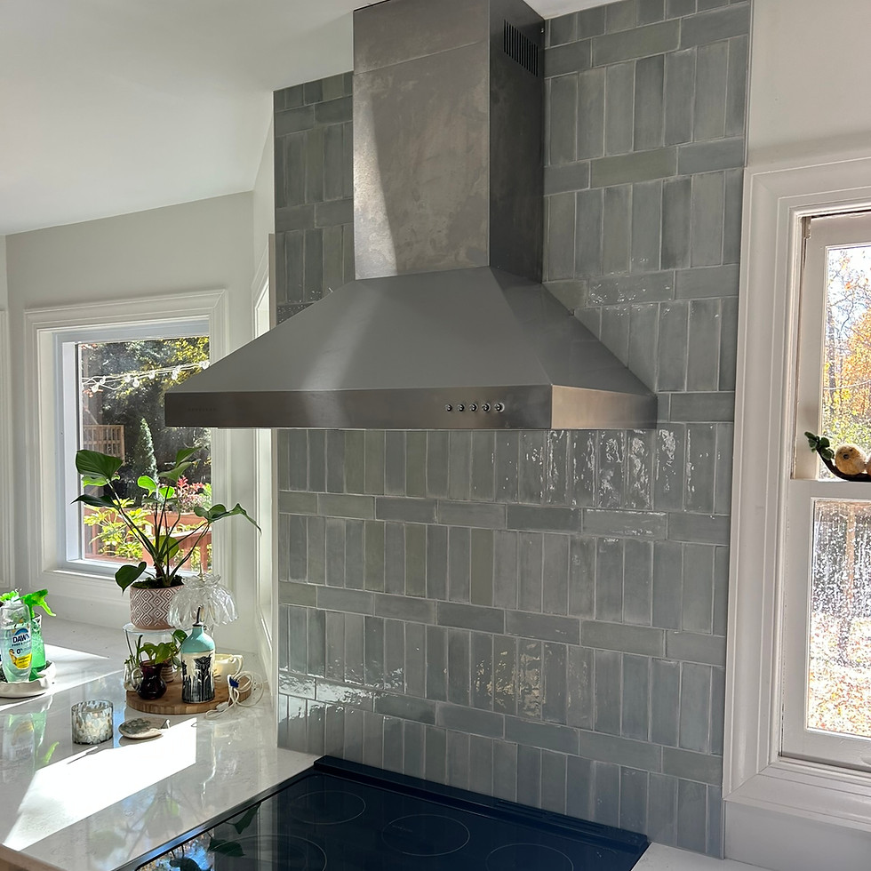 Kitchen with stainless steel range hood and gray tile backsplash