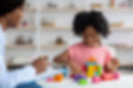 Female child development specialist observing cheerful child preschooler, happy little afr