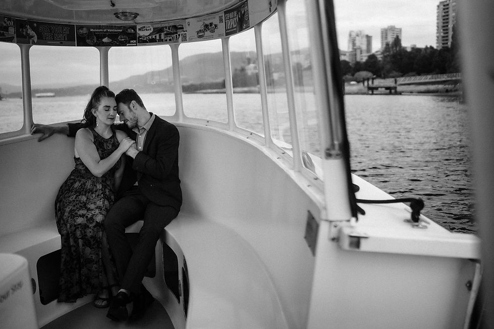 Couple with a colorful lollipop stands against an orange tiled wall. The woman in a red dress smiles, creating a playful mood. Dark and Moody Adventure Wedding Photography.