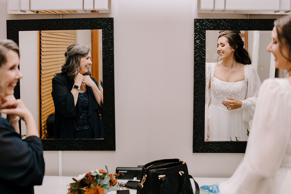 Allie by the Window: Bride standing by a large window overlooking the golf course, illuminated by natural light, wearing a white gown and veil.