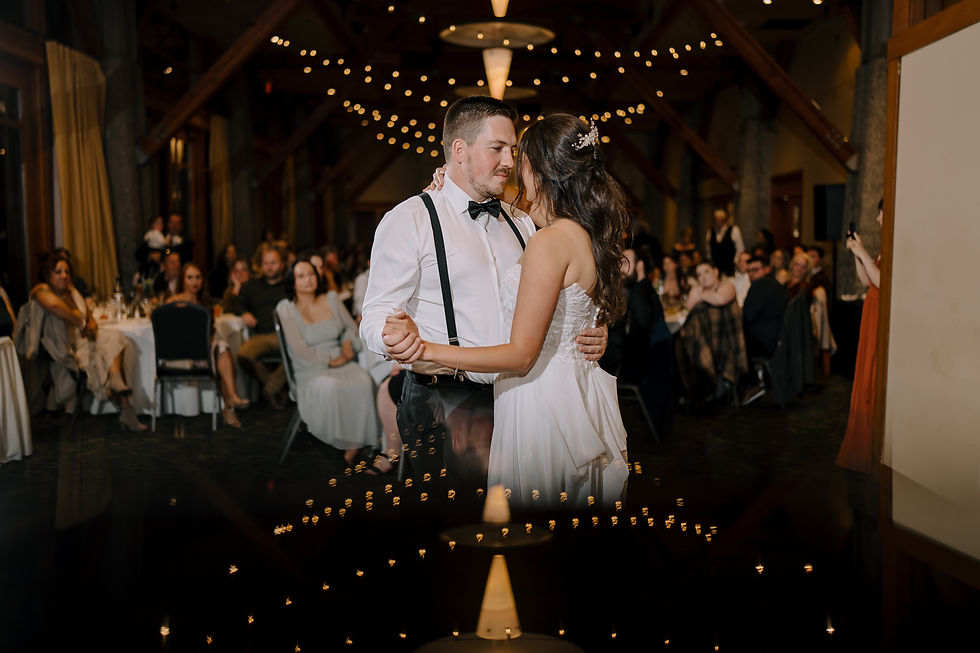First Dance: Bride and groom sharing their first dance under soft, romantic lighting, with guests watching in the background.
