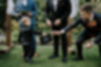 Ring Security Entrance: Three-year-old ring bearer, dressed as "Ring Security" with a badge and briefcase, walking down the aisle with his father.