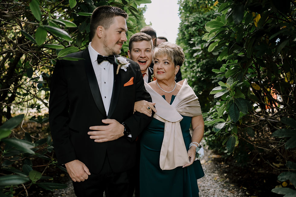 The groom and mother waiting for the ceremony to start as the groomsmen's is making jokes in the background.