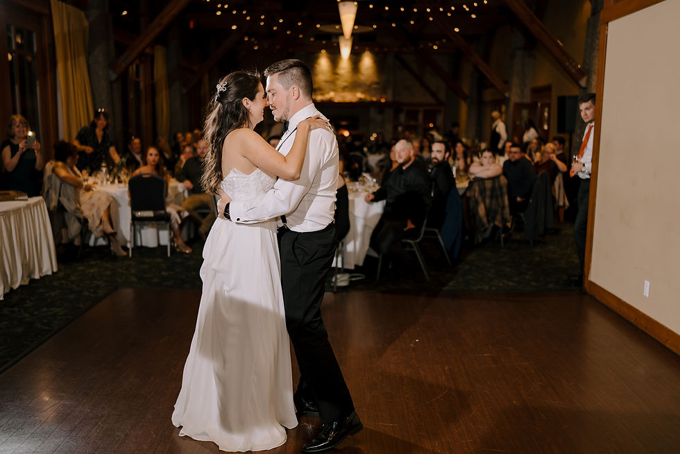 The First Dance: The bride and groom dancing under the warm lighting at the reception.