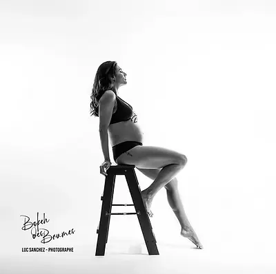 Femme enceinte assise en séance photo grossesse