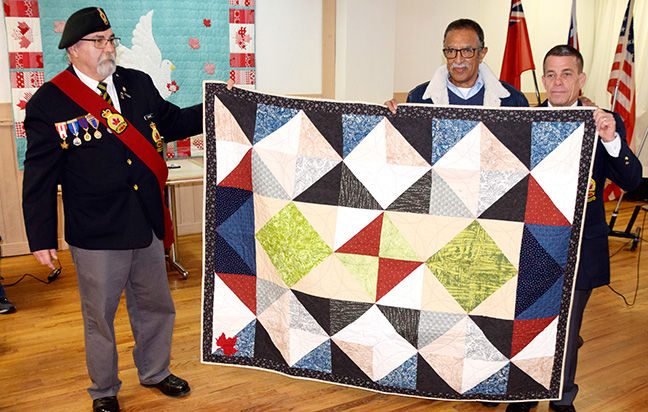 Wayne Hurst (centre) receives a Quilt of Valour. Also pictured are Sgt.-at-Arms Tim Girard (left) and Wilkie (right).