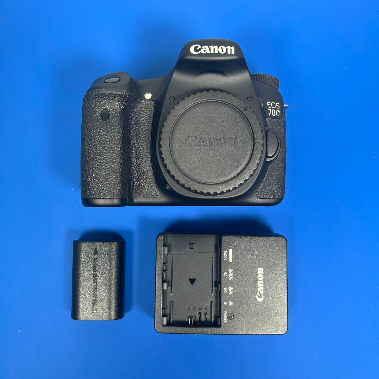Canon EOS 70D camera body with battery, charger, and body cap