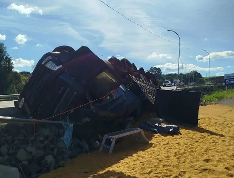 Caminhão tomba e mulher morre soterrada pela carga na BR-282 