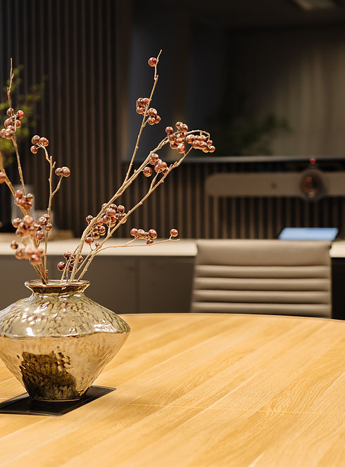 boardroom table in oak with a vase and plant