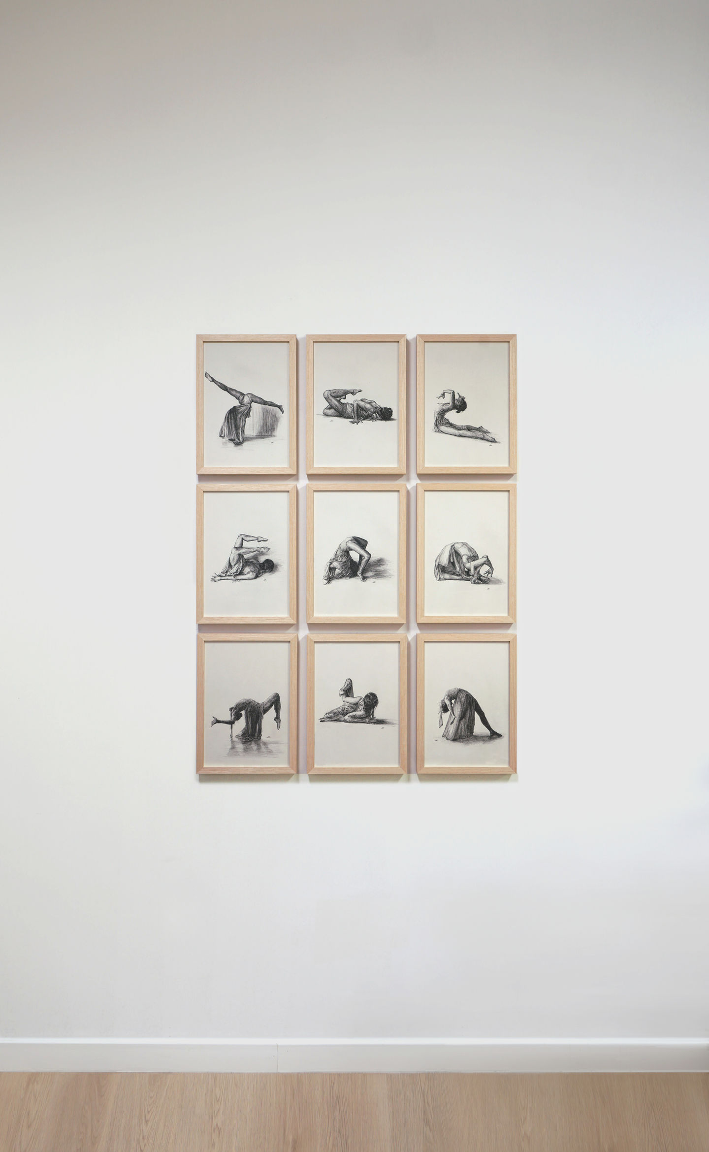 Installation view on a white wall of 9 pieces from the black and white pen on paper sketch illustration art series featuring an aerial contortionist dancing and posing on the floor