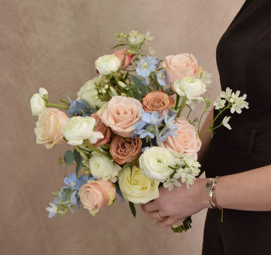 Blue, white, cappuccino, and blush bridal bouquet with a loose, flowing shape and natural movement. An elegant alternative pastel choice, perfect for modern and romantic weddings.