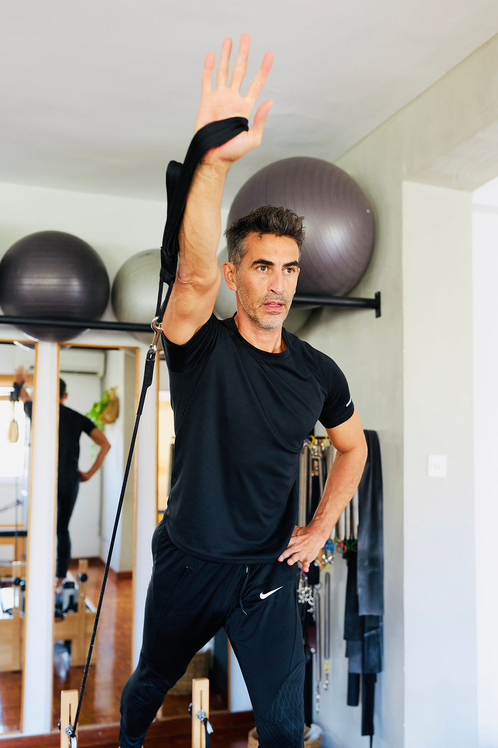 Alexander Michael, pilates instructor at No.75space studio in Limassol, performing a resistance exercise