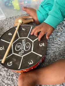 baby playing steel pan