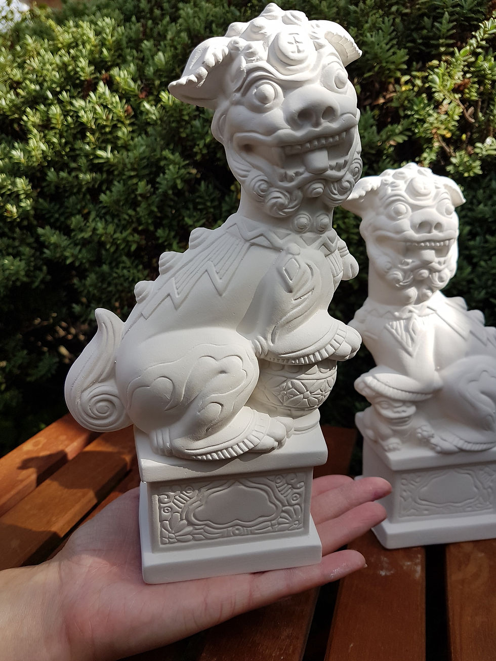 Thumbnail: Chinese Lion Dog pair of ceramic bisque figures in hand for scale