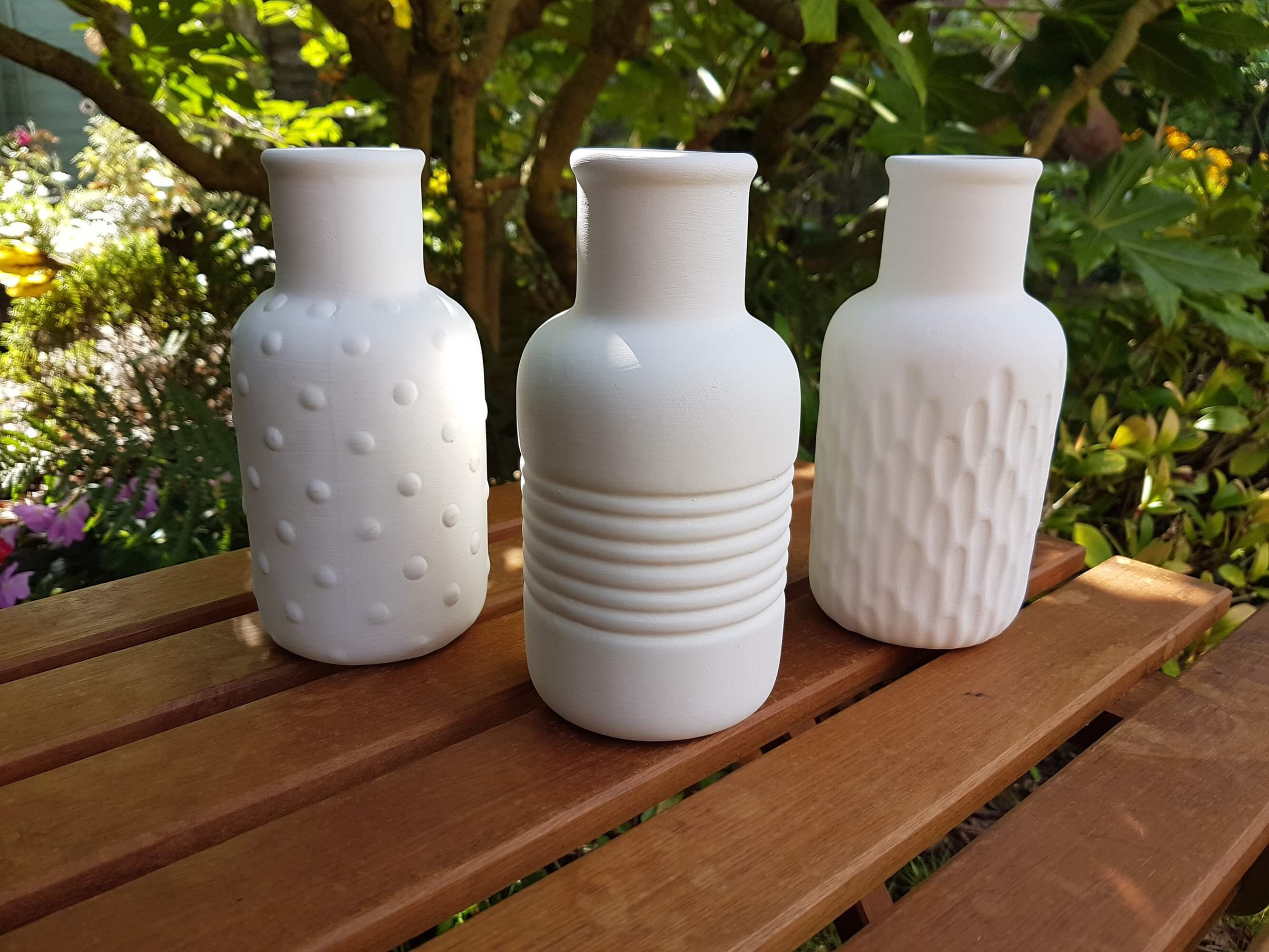 Set of 3 textured ceramic bisque vases front view