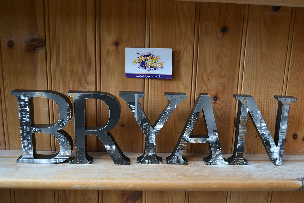 Thumbnail: The name Bryan in lack wooden letters with a New York cityscape design to the front