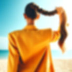 A woman holding her braided ponytail towards the sky wearing a yellow suit and a blazer an