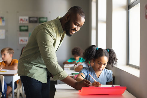 smiling-african-american-young-male-teacher-assisting-african-american-schoolgirl-desk-cla