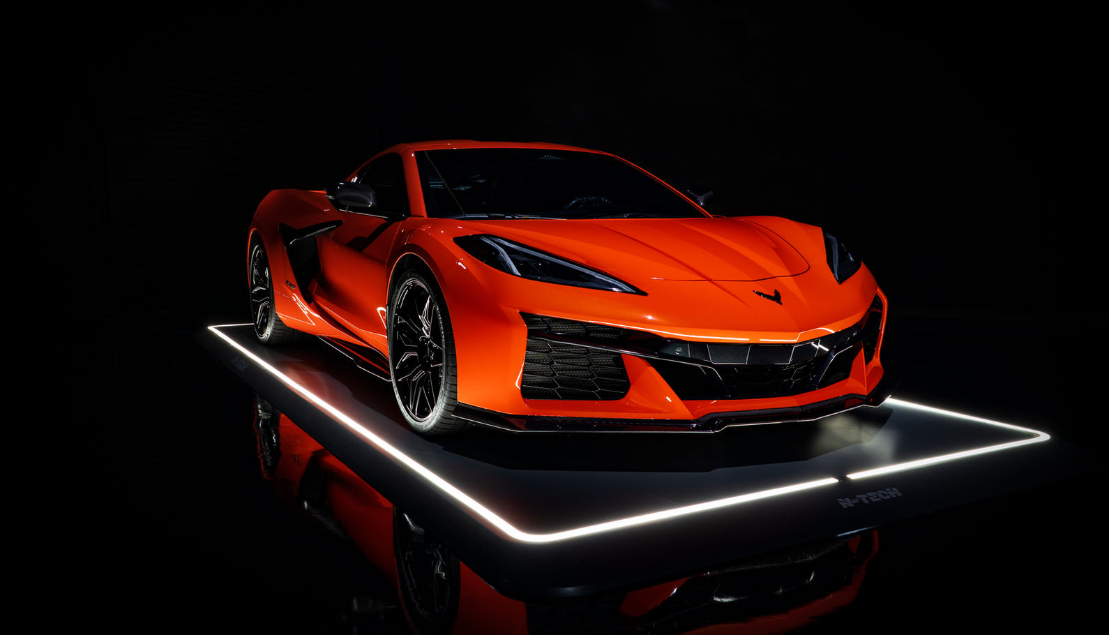 Orange Chevrolet Corvette Z06 (C8) angled front view on LED light platform. Full paint protection film completed at N-TECH in Riverside, California.