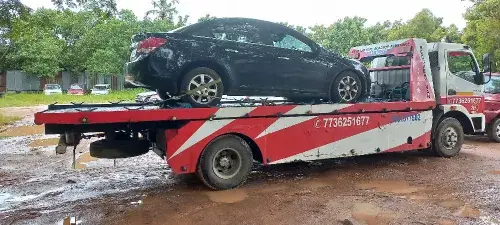 a flatbed recovery van towing a car