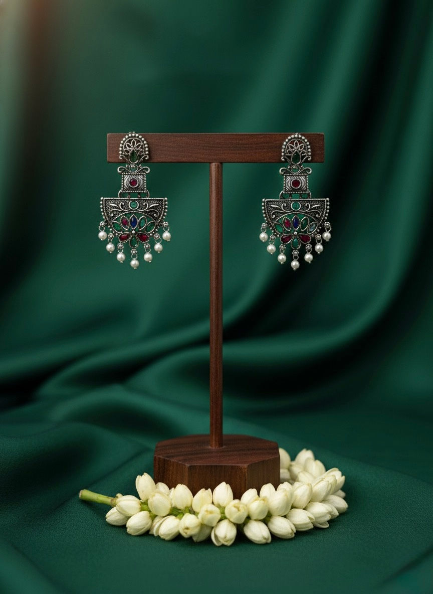 Silver earrings on display, beautiful green backdrop, Lavish Jewellery.