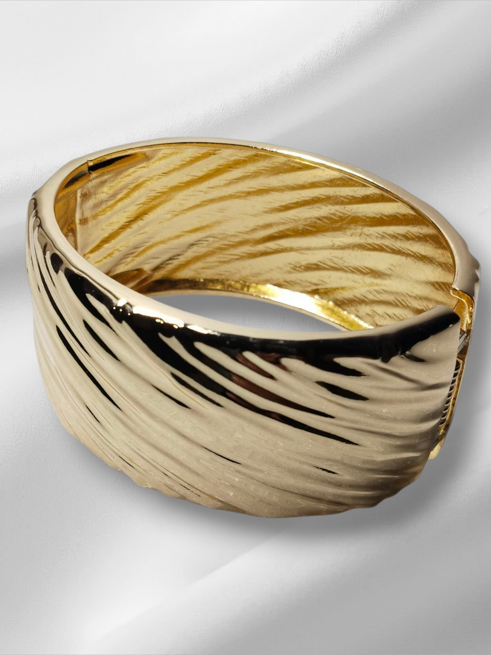 Elegant gold bangle bracelet, wavy texture, for women, Lavish Jewellery on display.