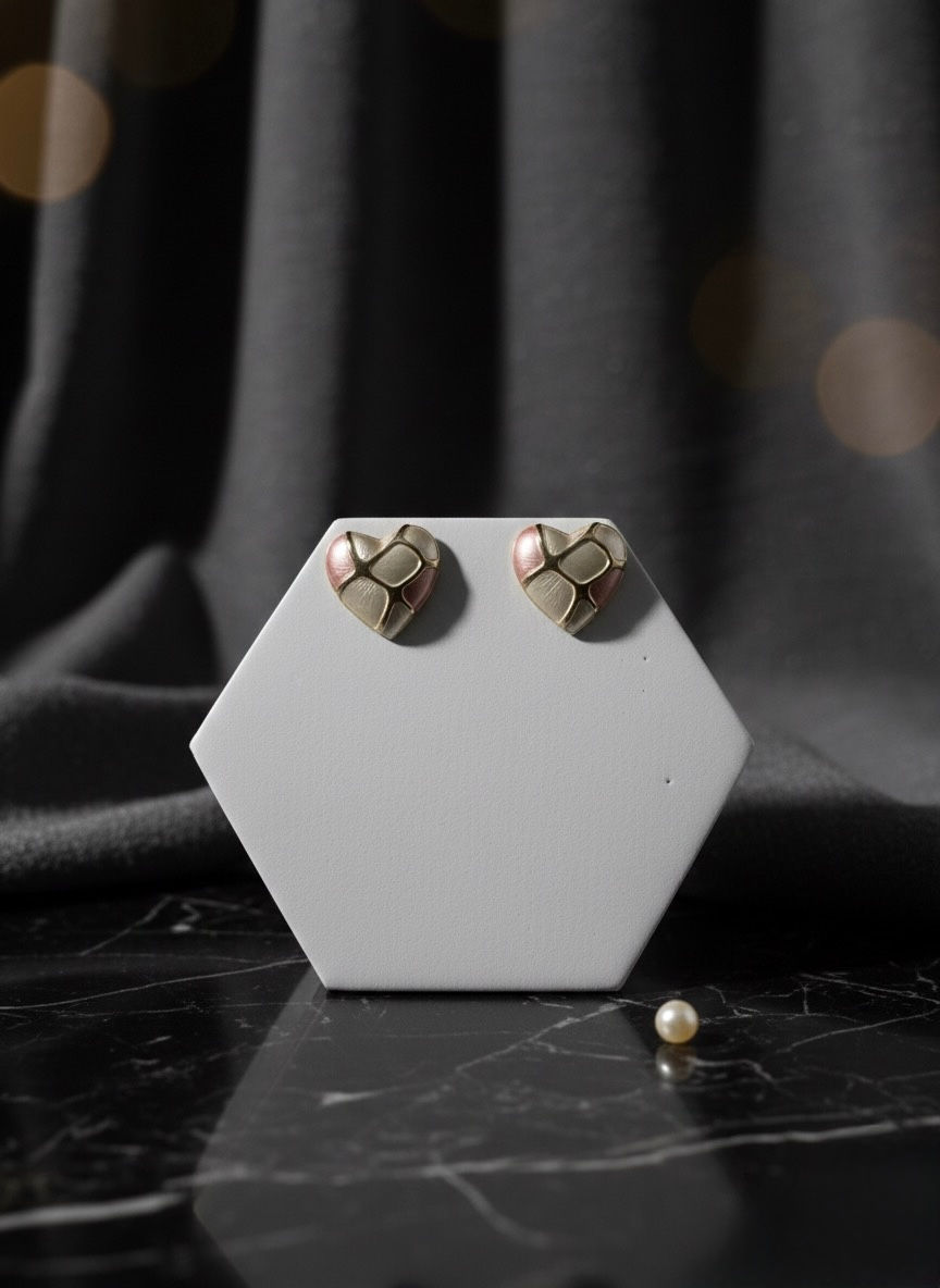 Heart-shaped earrings displayed on a white stand with a pearl; Lavish Jewellery.