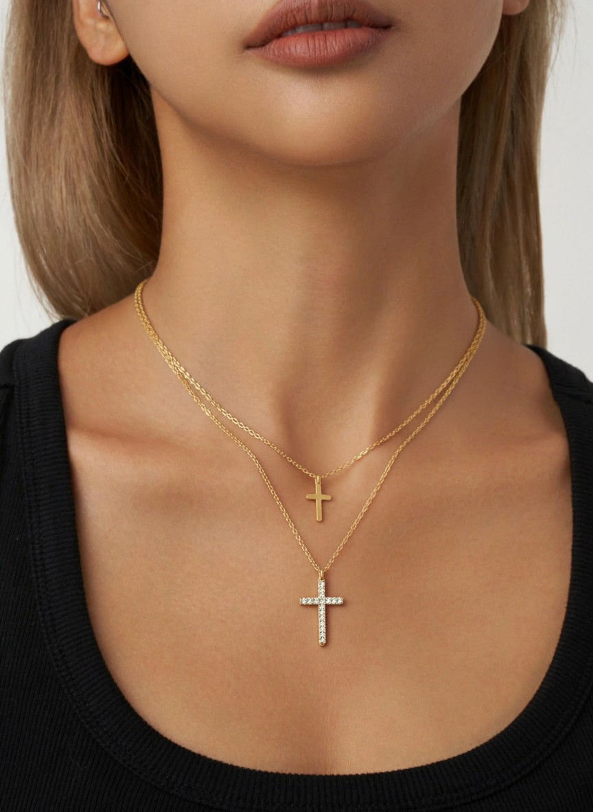 Woman wearing two gold cross necklaces, close up shot. Lavish Jewellery.